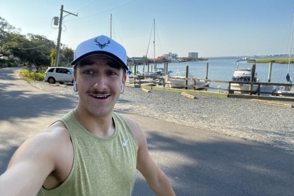 Young man running along the coastal waterway