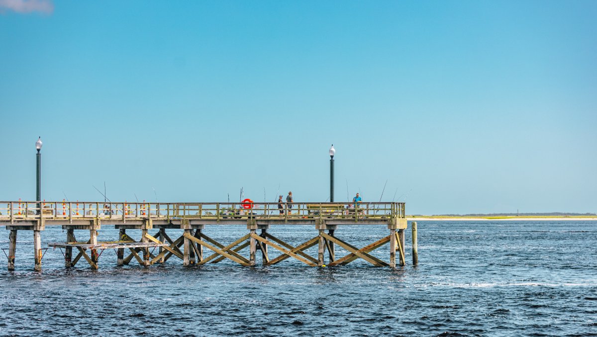 Anglers fishing from town fishing pier that extends into the Cape Fear River