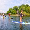 Three friends stand-up paddleboarding on calm Lake Norman waters.